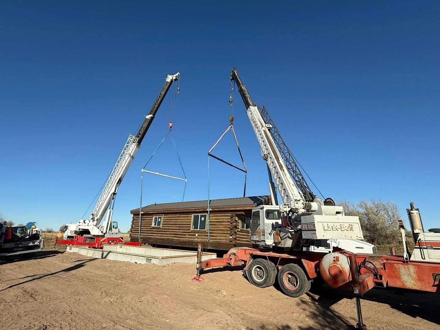 Cranes setting a finished cabin